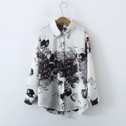 White shirt with black floral pattern on a hanger against a white background