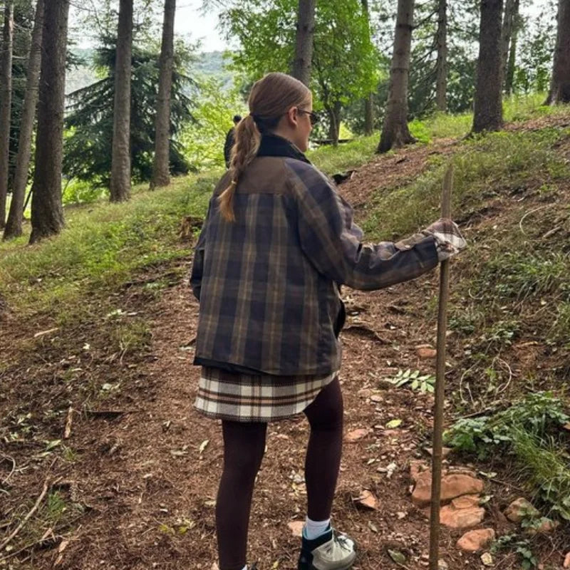 Person hiking in a forest holding a walking stick
