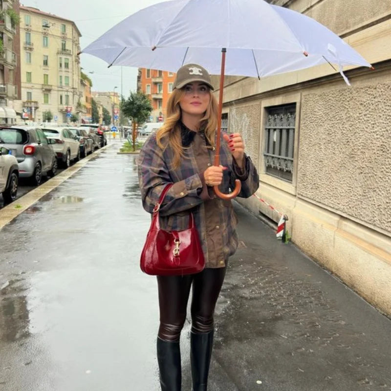 Woman holding a white umbrella on a city street