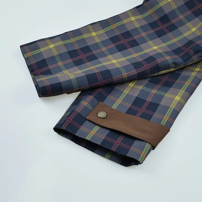 Plaid fabric with brown leather trim on a white background