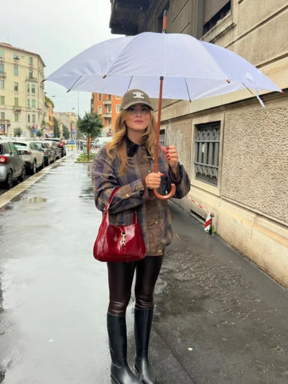 Woman holding a white umbrella on a city street