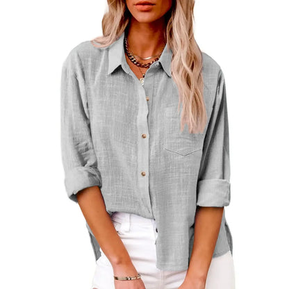 Woman wearing a light gray button-up shirt with rolled-up sleeves on a white background