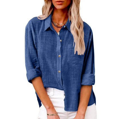 Woman wearing a blue button-up shirt with rolled-up sleeves on a white background