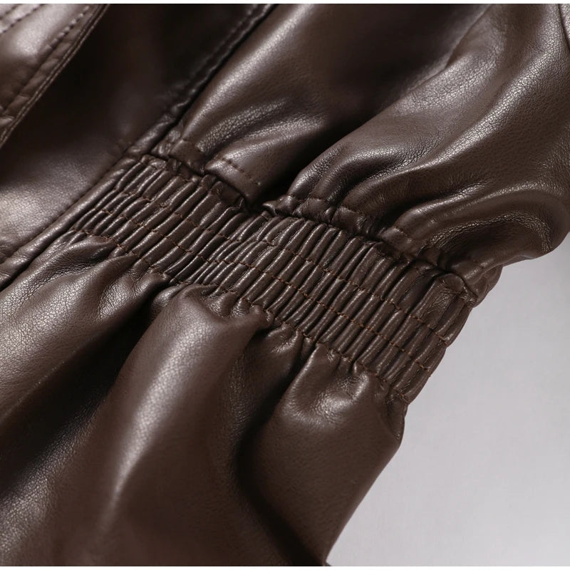 Close-up of brown leather pants with a focus on stitching detail.