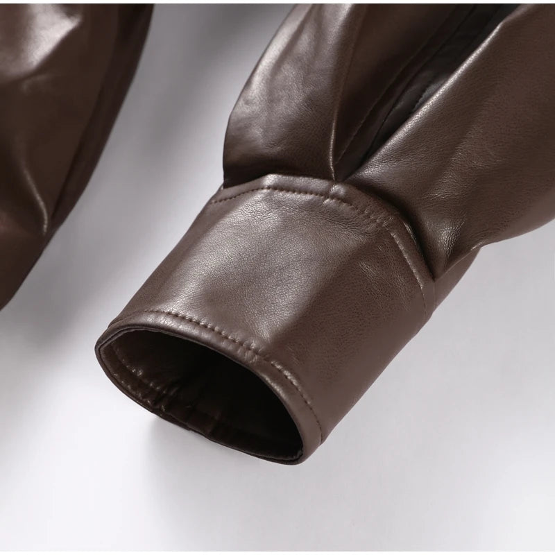 Close-up of brown leather sleeve on a light gray background