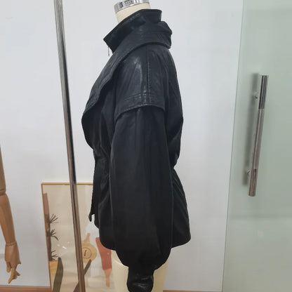 Black leather jacket on a mannequin against a white wall.