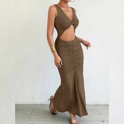 Woman wearing a brown outfit with a top and skirt against a white wall.