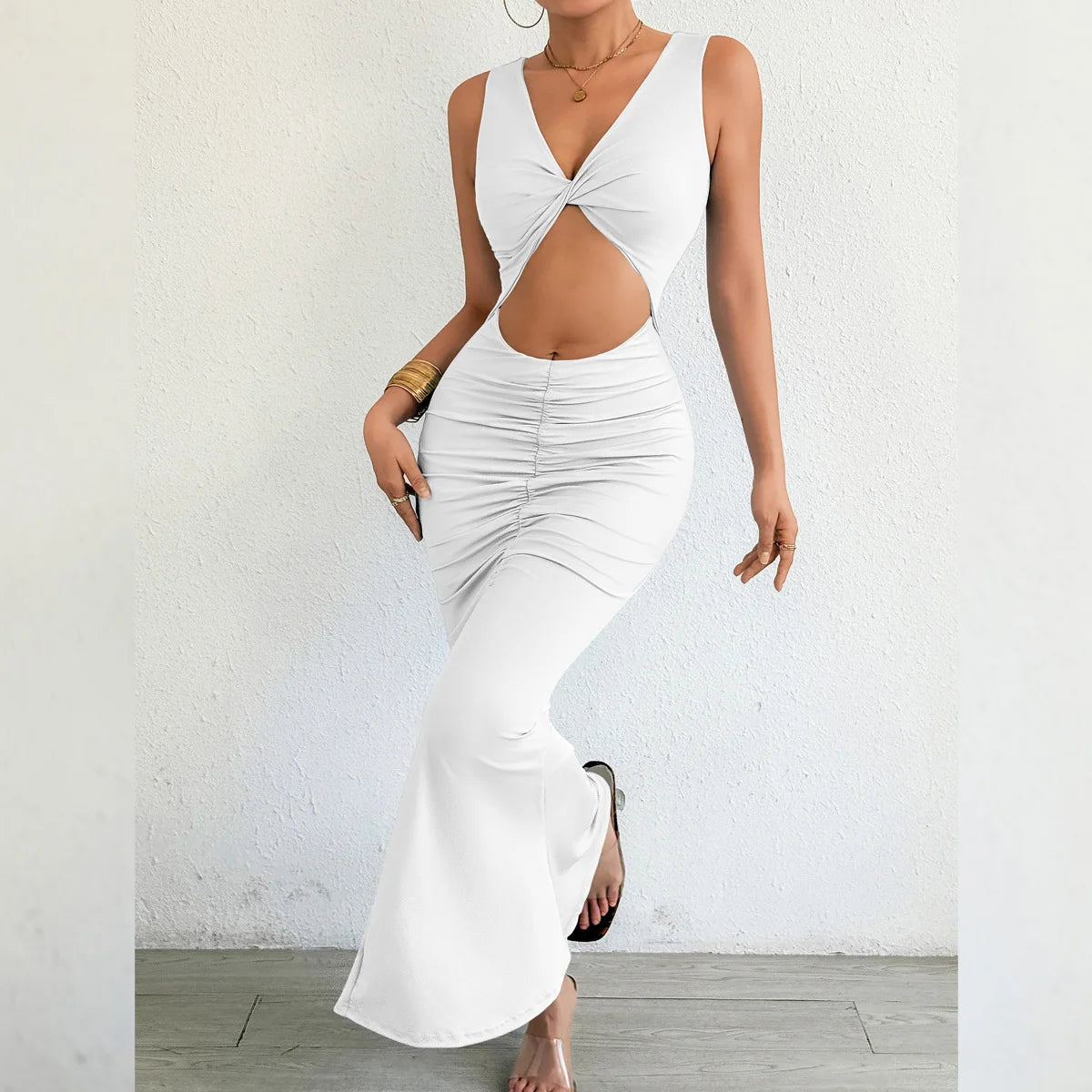 Woman wearing a white dress with cut-out design against a plain background