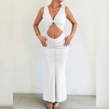 Woman wearing a white sleeveless top and pants against a plain background