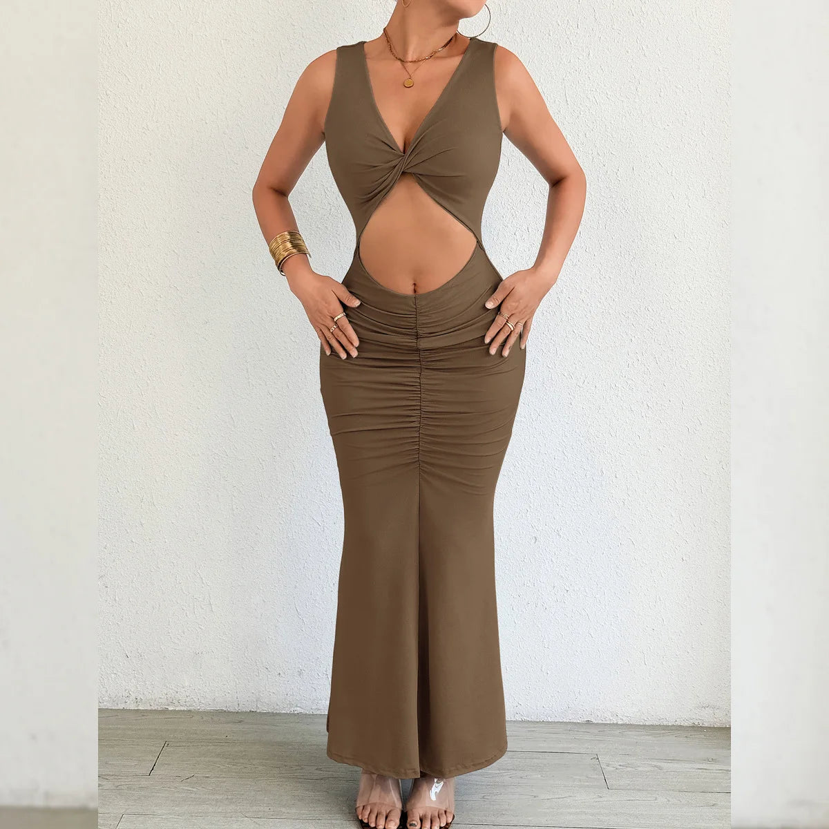 Brown dress with cut-out design worn by a person against a white wall.