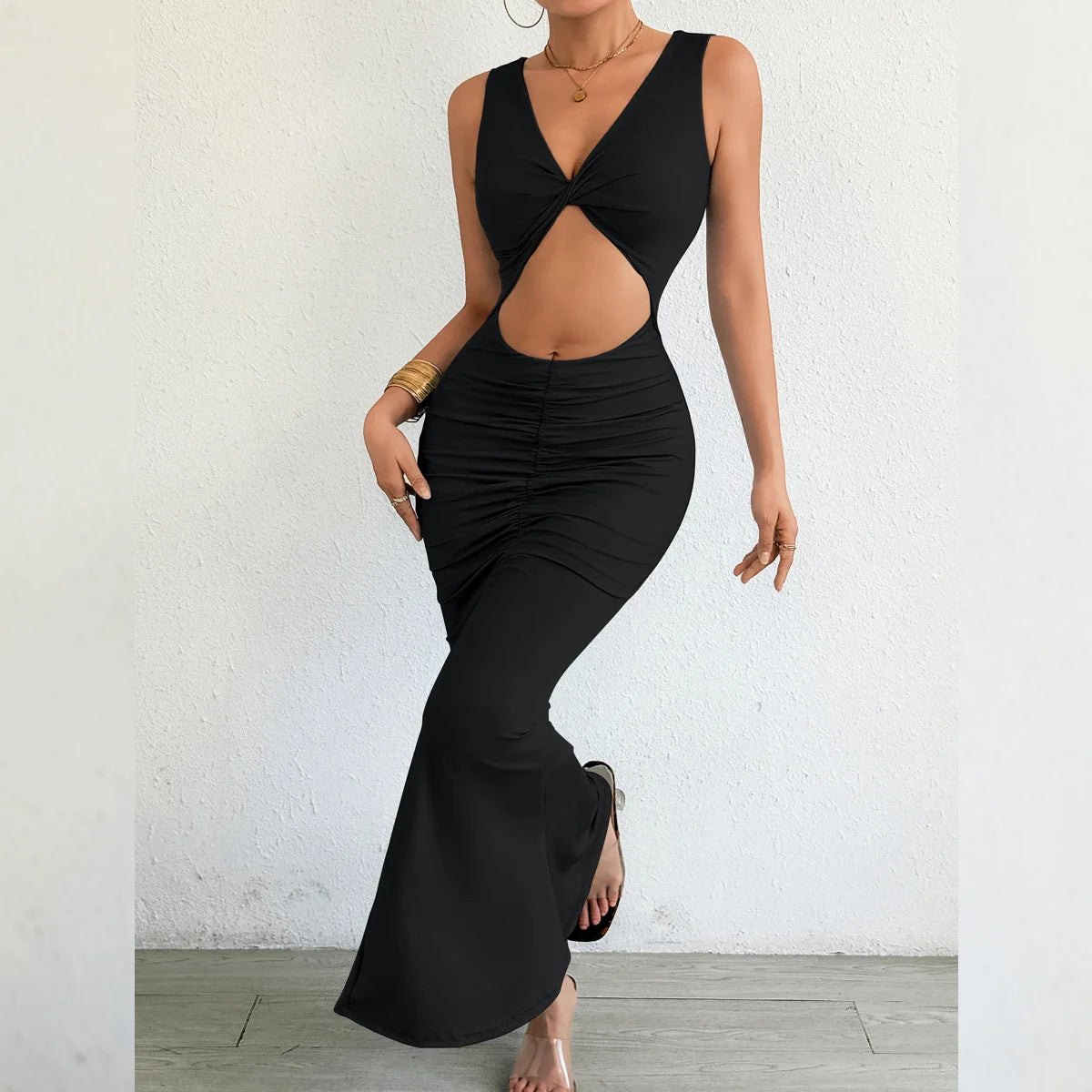 Black sleeveless dress with cut-out design worn by a model against a white background