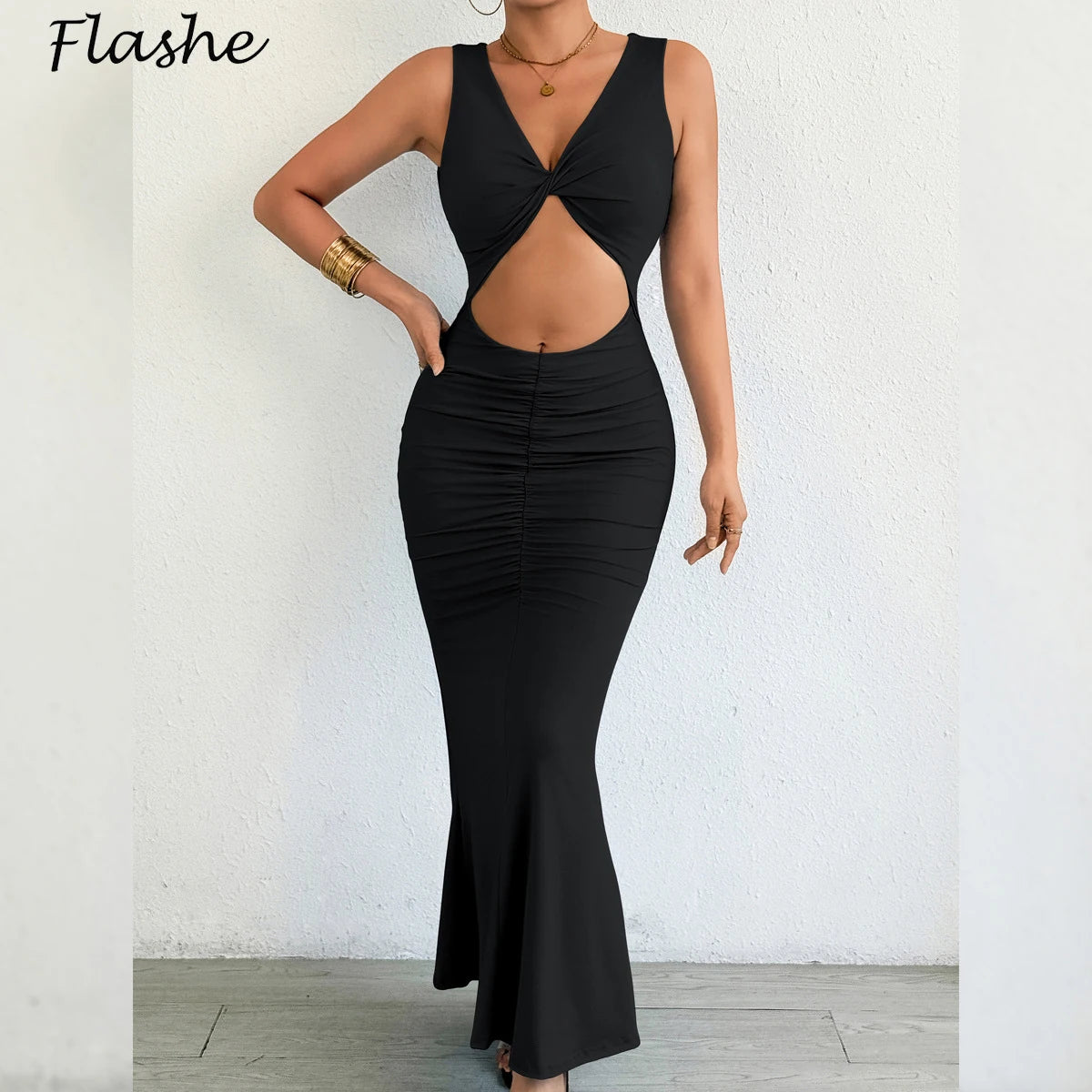 Black dress with cut-out design worn by a person against a white wall, brand 'Flashe' visible.