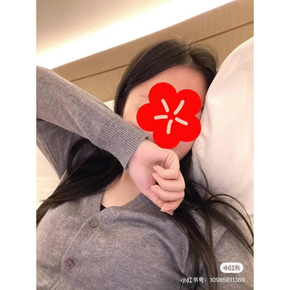 Person wearing a gray sweater with a red flower overlay on a neutral background