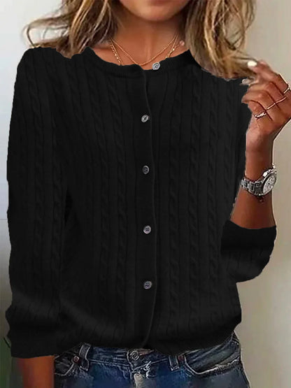 Black cable knit cardigan worn by a person with a neutral background