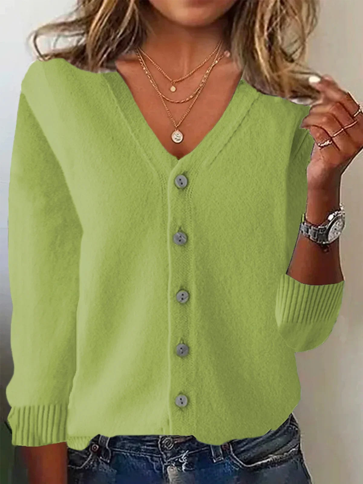 Green cardigan worn by a person with a neutral background