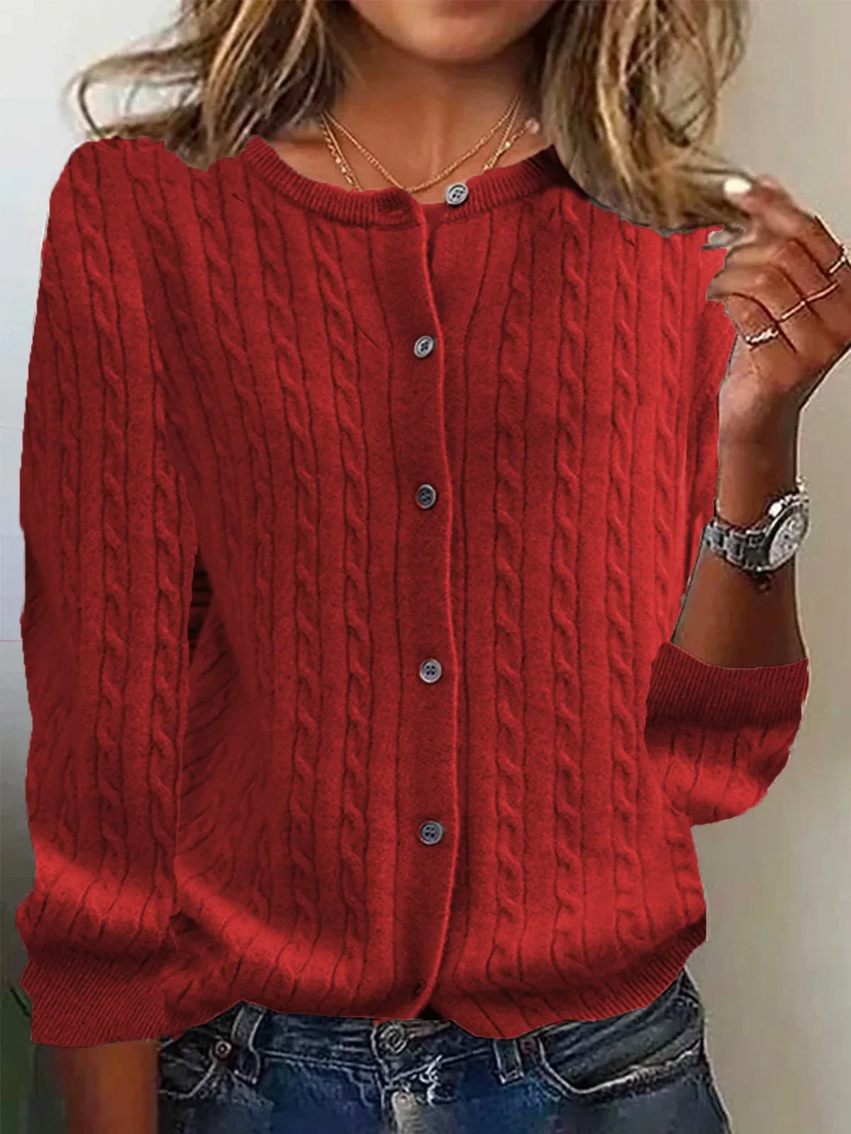 Red cable knit cardigan worn by a person with a neutral background