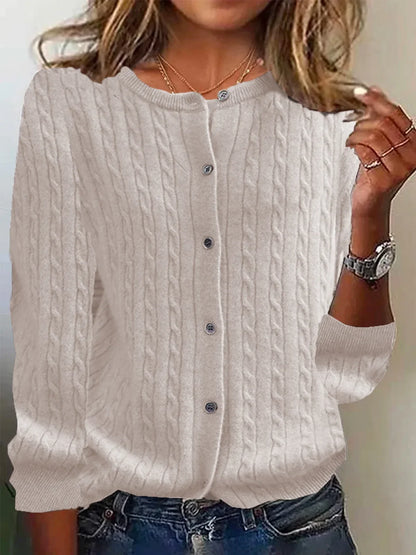 White cable knit cardigan worn by a person with a neutral background