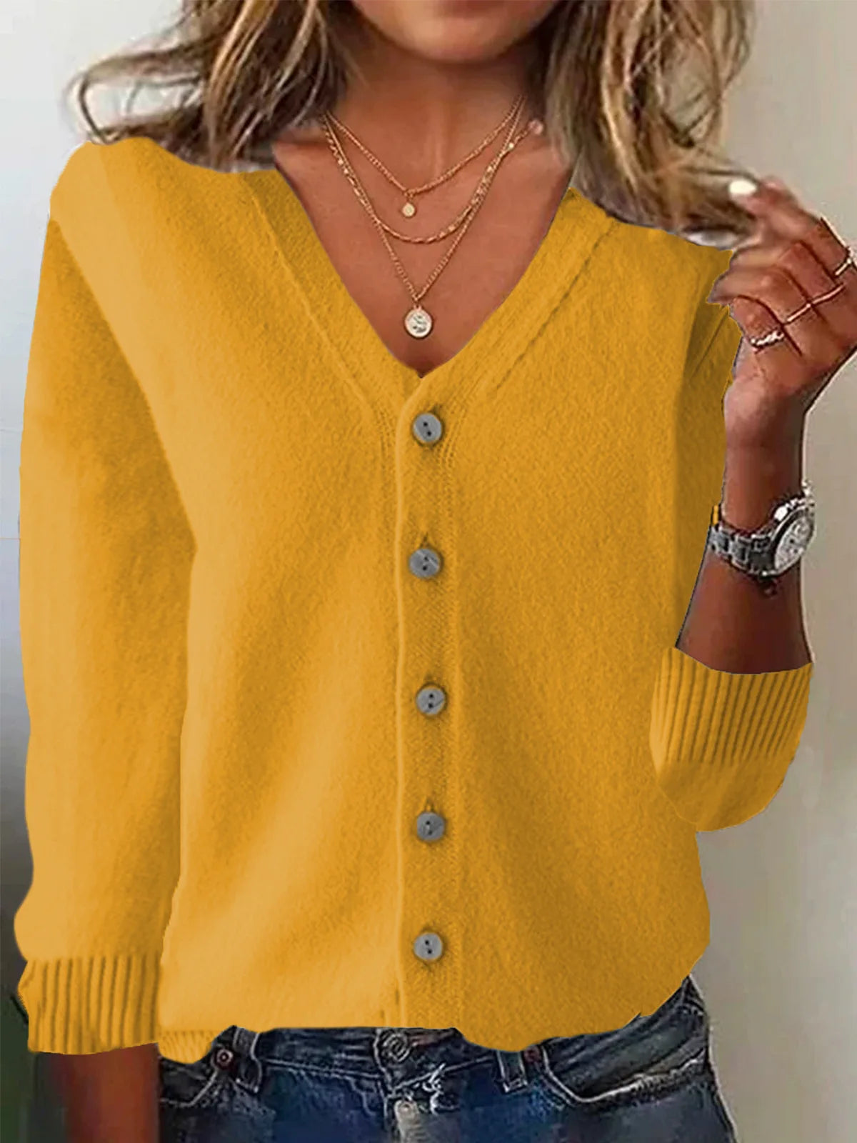 Yellow cardigan worn by a person with a neutral background