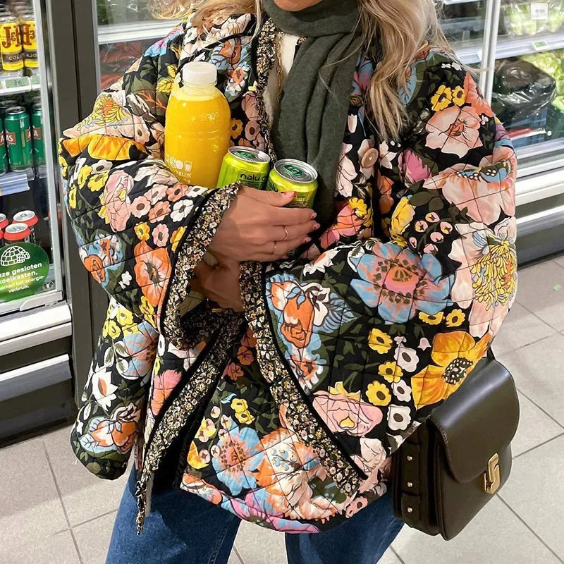 Person wearing a colorful floral jacket holding drinks in a store setting