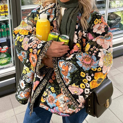 Person wearing a colorful floral jacket holding drinks in a store setting