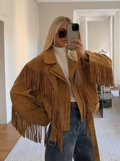Person wearing a brown fringed jacket in a room.