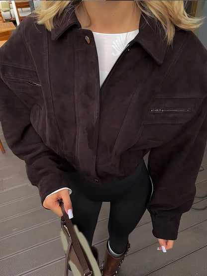 Person wearing a dark brown jacket with a blurred background