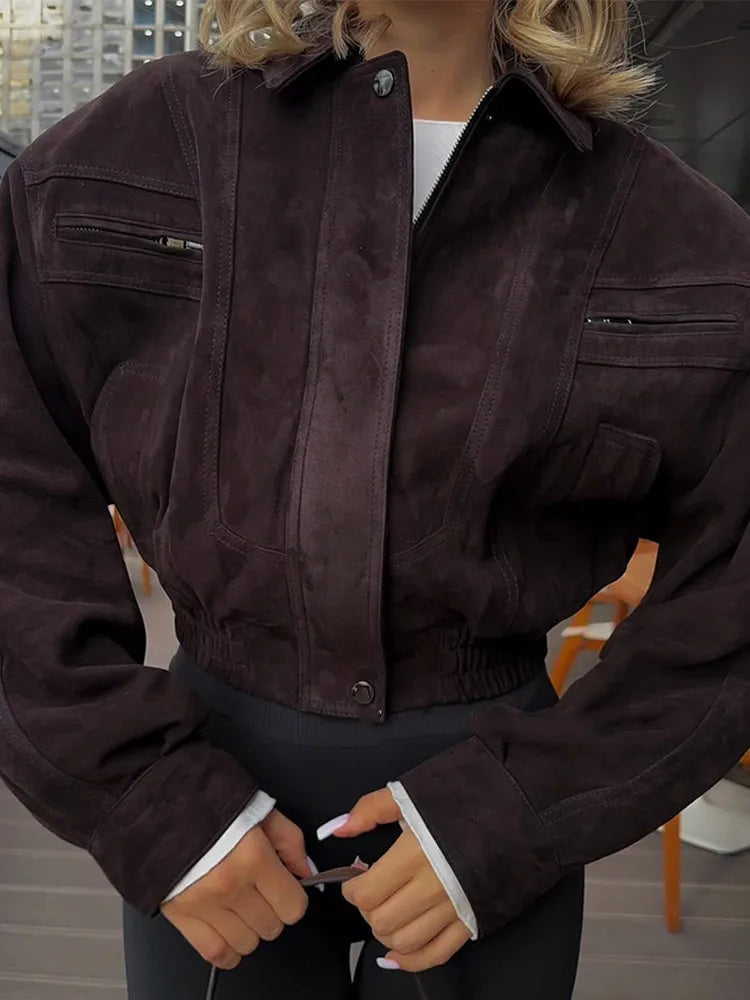 Person wearing a dark brown jacket with a blurred indoor background