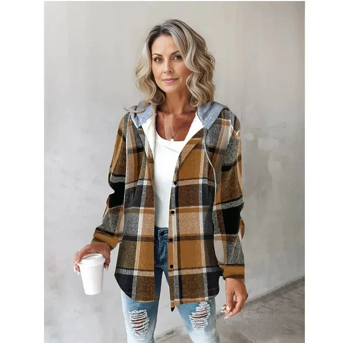 Woman wearing a plaid shirt over a white top and ripped jeans, holding a coffee cup.