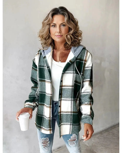 Woman wearing a plaid shirt and jeans, holding a coffee cup against a plain background