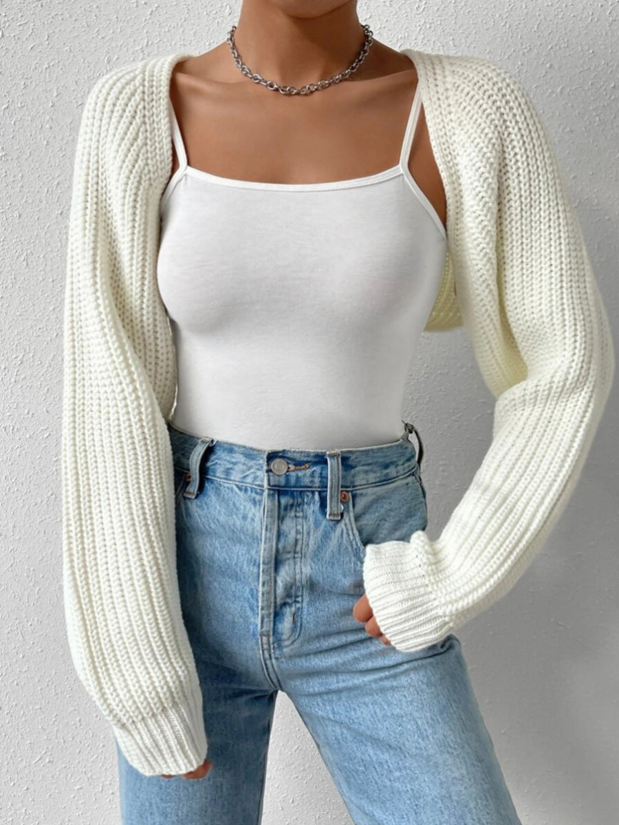 Mannequin wearing a white knit cardigan, white tank top, and blue jeans against a gray background